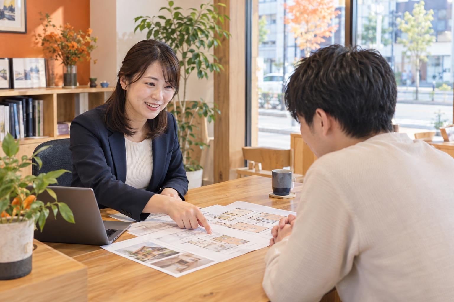 お店のカウンターで、スタッフが間取り図を説明している